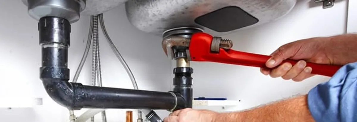 Garbage disposal repair technician tightening the sink drain and disposal connection in Duluth, MN