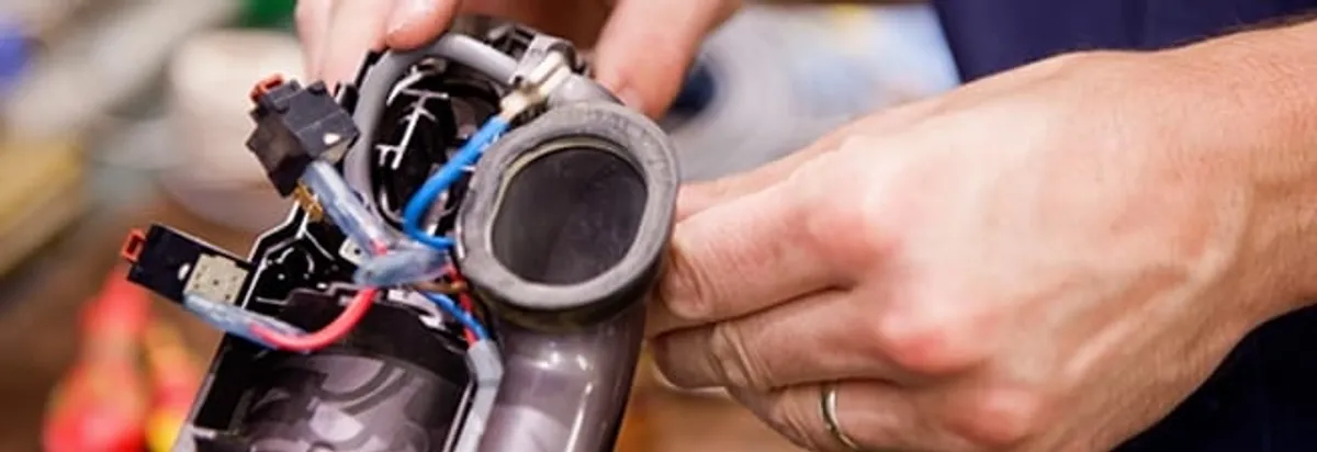 Vacuum repair technician reconnecting wiring and components in Duluth, MN
