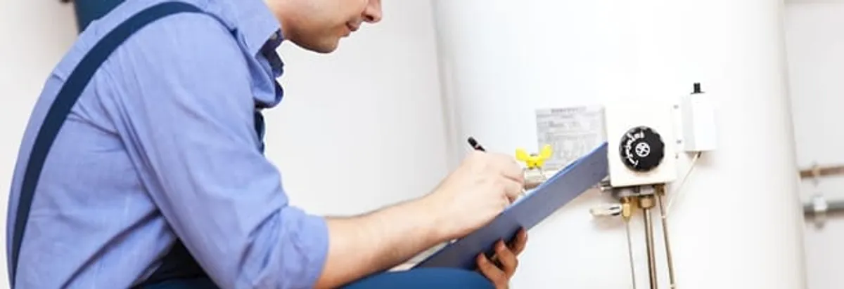 Water heater repair technician inspecting the unit and recording service notes in Duluth, MN