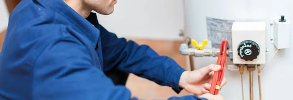 Water heater repair technician adjusting the temperature control and gas valve in Duluth, MN